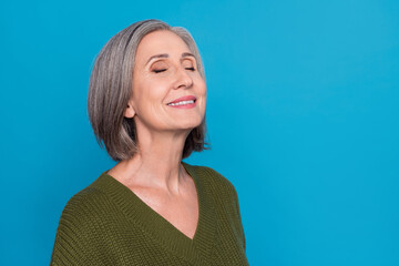 Sticker - Photo of toothy beaming pleasant woman bob hairstyle dressed khaki sweater eyes closed enjoy moment isolated on blue color background