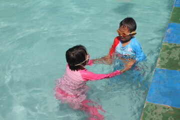 boys and girls practice swimming and playing in water
