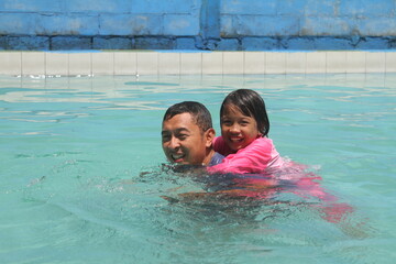 boys and girls practice swimming and playing in water
