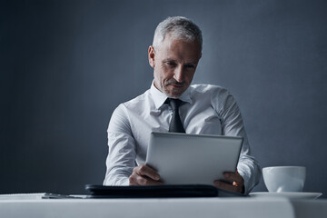 Leinwandbilder - Tablet, accountant and mature business man in studio isolated on a dark background mockup space. Technology, reading and senior manager at desk for working on project, audit email or research app.