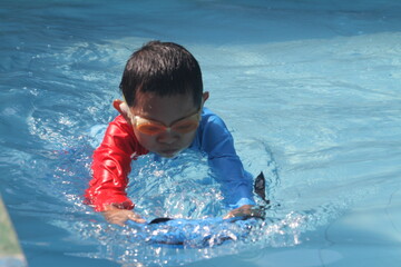 boys and girls practice swimming and playing in water
