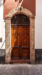 Wall Mural - Vintage brown wooden front door on the facade of a building, AI generated