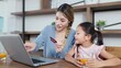 © M Stocker - Happy asian mother and little daughter holding credit card for making online shopping on laptop in living room at home enjoying leisure together. Online shopping concept