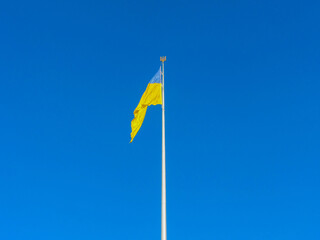 Ukraine flag large national symbol fluttering in blue sky. Large