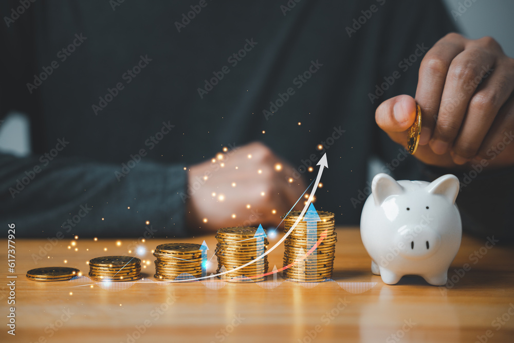 Businessman inserting coin into piggy bank with chart graph showing ...