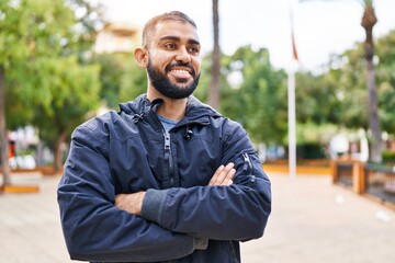 Sticker - Young hispanic man standing with arms crossed gesture at park