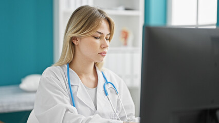 Poster - Young blonde woman doctor using computer at clinic