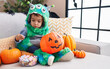 © Krakenimages.com - Adorable hispanic boy having halloween party holding sweets at home