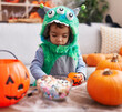 © Krakenimages.com - Adorable hispanic boy having halloween party holding sweets at home