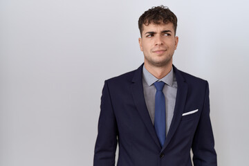 Poster - Young hispanic business man wearing suit and tie smiling looking to the side and staring away thinking.