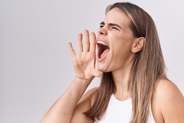 Poster - Hispanic young woman standing over white background shouting and screaming loud to side with hand on mouth. communication concept.