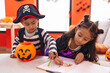 © Krakenimages.com - Adorable boy and girl having halloween party drawing on notebook at home