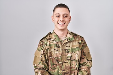 Wall Mural - Young man wearing camouflage army uniform with a happy and cool smile on face. lucky person.