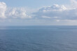 © Mint Images - White clouds in a blue sky over the Pacific ocean at dusk
