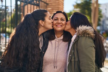 Poster - Three woman mother and daughters standing together and kissing at street