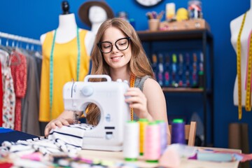 Sticker - Young woman tailor smiling confident using sewing machine at clothing factory