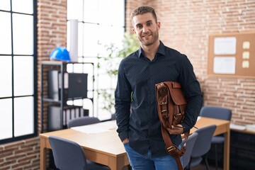 Canvas Print - Young caucasian man business worker smiling confident holding briefcase at office