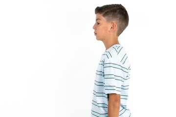 Wall Mural - Little hispanic boy wearing  striped T-shirt  looking to side, relax profile pose with natural face with confident smile.