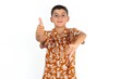 Little hispanic kid boy wearing hawaiian shirt showing thumbs up and thumbs down, difficult choose concept
