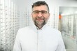 © Serhii - Portrait of a handsome ophthalmologist in front of the showcase with eyeglasses in the hospital.