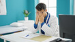 © Krakenimages.com - Young hispanic man doctor stressed sitting on table at clinic
