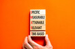 SMART symbol. Concept words SMART specific measurable attainable relevant time-based on block. Beautiful orange background. Business SMART specific measurable attainable relevant time-based concept.