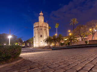 Wall Mural - The golden tower of Torre del Oro in night illumination at sunset.