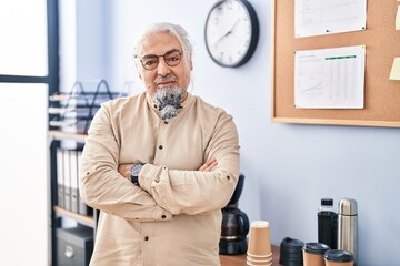 Wall Mural - Middle age grey-haired man business worker standing with arms crossed gesture at office