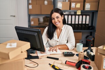 Canvas Print - Young beautiful hispanic woman ecommerce business worker writing on notebook at office