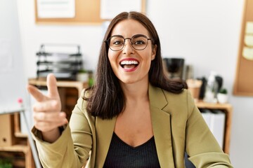 Canvas Print - Young beautiful hispanic woman business worker sitting on table speaking at office