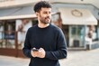 © Krakenimages.com - Young arab man smiling confident using smartphone at street