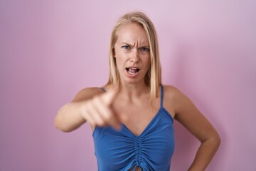 Canvas Print - Young caucasian woman standing over pink background pointing displeased and frustrated to the camera, angry and furious with you