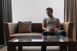 © Sevendeman - Lonely asian man sits on the sofa thinking of his lover.
