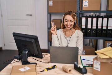 Poster - Hispanic woman working at small business ecommerce wearing headset smiling happy pointing with hand and finger to the side