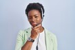 © Krakenimages.com - African american woman wearing call center agent headset looking confident at the camera smiling with crossed arms and hand raised on chin. thinking positive.