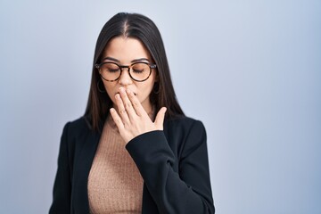 Sticker - Young brunette woman standing over blue background bored yawning tired covering mouth with hand. restless and sleepiness.