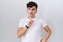 Young Non Binary Man Wearing Casual White T Shirt Thinking Concentrated About Doubt With Finger On Chin And Looking Up Wondering