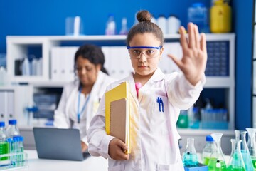 Sticker - Mother and young daughter working at scientist laboratory with open hand doing stop sign with serious and confident expression, defense gesture