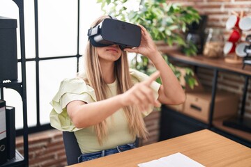 Poster - Young beautiful hispanic woman business worker using virtual reality glasses at office