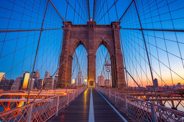  Cityscape image of Brooklyn Bridge with Manhattan skyline in the background.
