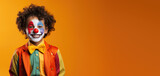 Cute Young Boy Dressed as a Clown for Halloween on an Orange Banner with Space for Copy