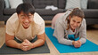 © Krakenimages.com - Man and woman couple smiling confident training abs exercise at home
