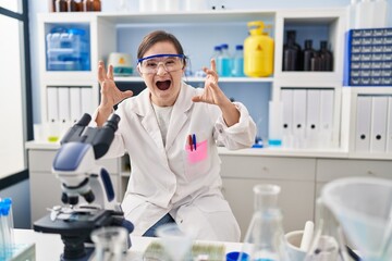 Sticker - Hispanic girl with down syndrome working at scientist laboratory shouting frustrated with rage, hands trying to strangle, yelling mad