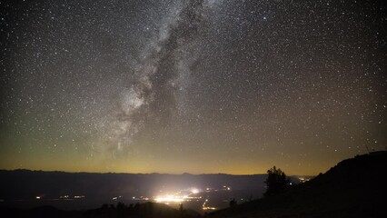 Wall Mural - amazing time-lapse of the night sky rotating above a small town.