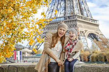 Autumn getaways in Paris with family. Portrait of happy mother and child travellers on embankment in Paris, France having fun time