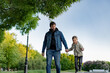 © Yulia Raneva - Caucasian bearded man with his little son walking in park holding hands