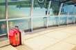 © Designpics - stack of traveling luggage in airport terminal and passenger plane flying over building in city