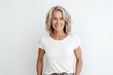 Happy Mature Woman Looking At Camera And Smiling While Standing Against White Background