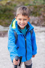 Canvas Print - Happy hiking boy with trekking sticks in the mountains. Norway