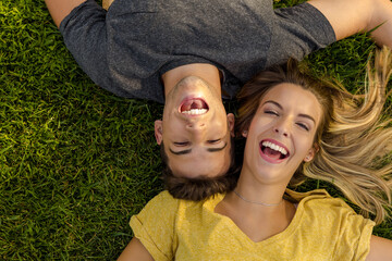 Canvas Print - Portrait of a young beautiful couple lying on the grass